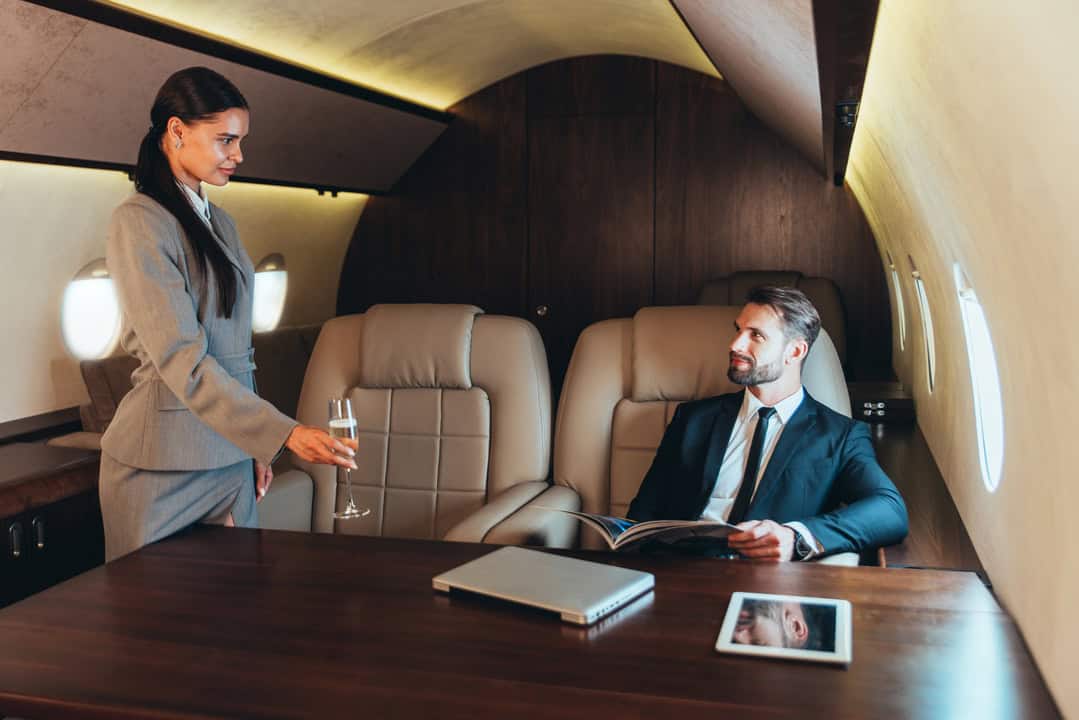 manager giving champagne businessman airplane new